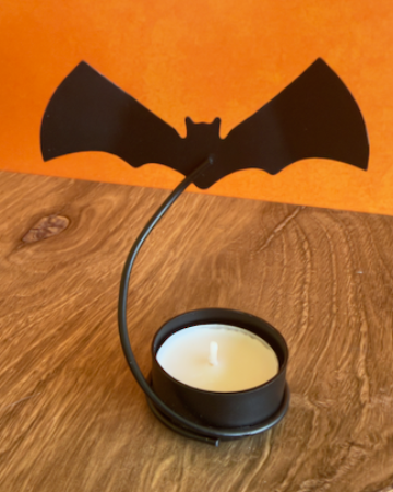 A set of 2 Halloween-themed bat-shaped tealight candle holders with two tea light candles, when lit these cast a dramatic shadow of flying bats on any wall. Made of Metal.