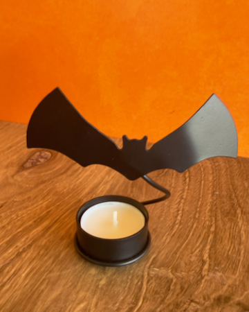 A set of 2 Halloween-themed bat-shaped tealight candle holders with two tea light candles, when lit these cast a dramatic shadow of flying bats on any wall. Made of Metal.