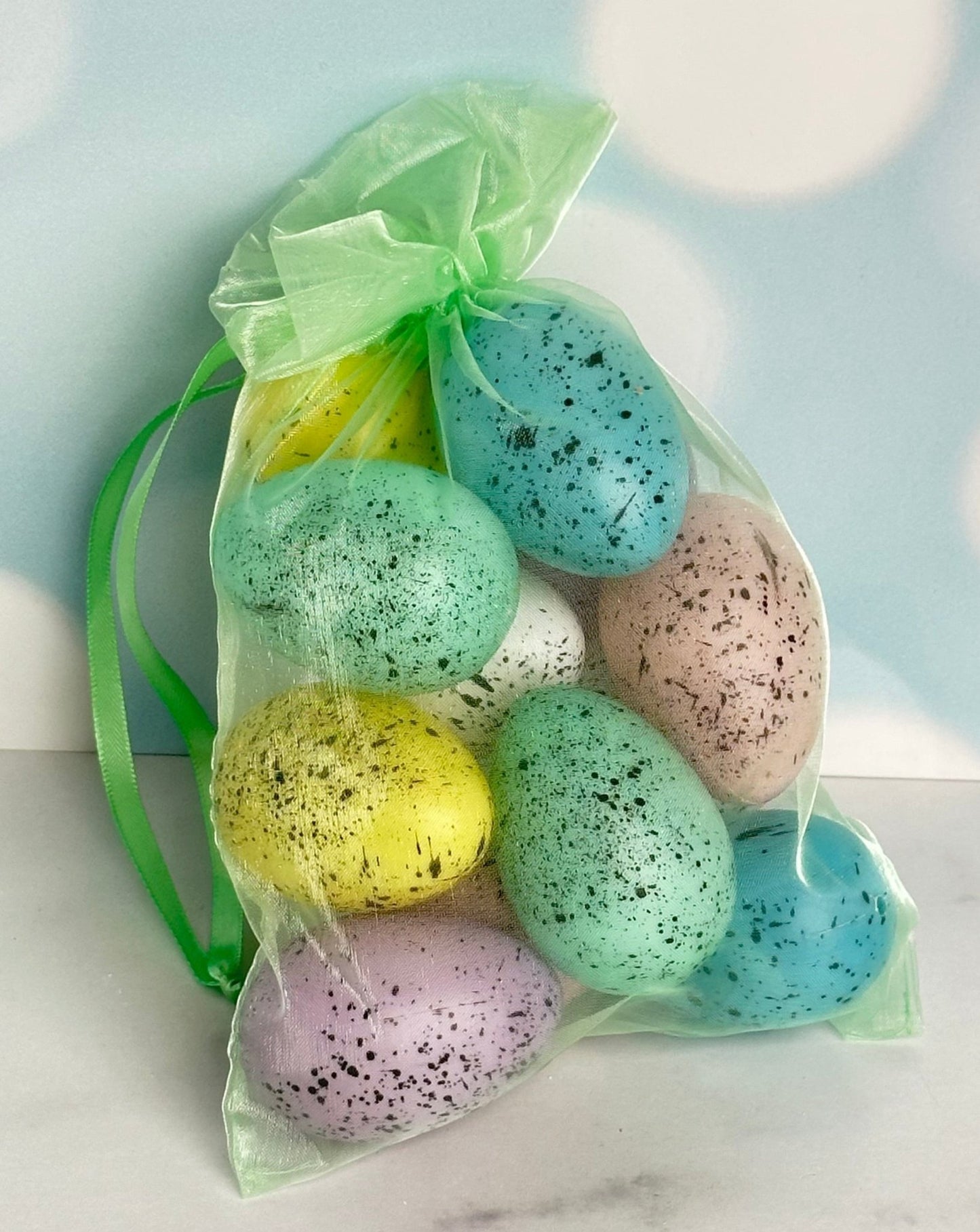 set of 12 speckled faux easter eggs in a green organza bag