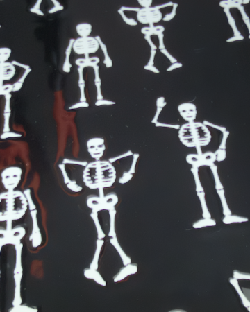 A square ceramic black appetizer tray with rounded corners, featuring a repeating pattern of small white stick-figure skeletons. Approx. 8.25" square.