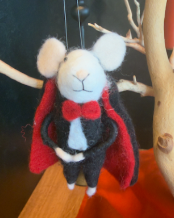 A felted wool vampire mouse hanging from a branch, wearing a black suit, white collar, and red cape. Approx 6" tall.