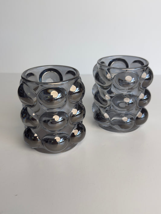 these modern glass votive holders have an iridescent shine that really makes them pop wherever they are placed.

this set of 2 will hold either a votive or tealight candle

approx. 3.5" high x 3" wide